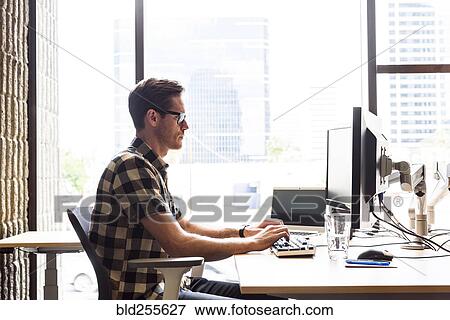 Stock Photo - Caucasian man using computer in office. Fotosearch