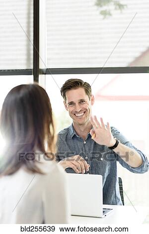 Caucasian man using laptop gesturing to woman View Large Photo Image Stock Photo - Caucasian man using laptop gesturing to woman. Fotosearch