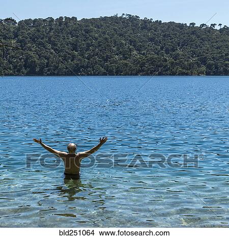Caucasian man wading in water View Large Photo Image Picture - Caucasian man wading in water. Fotosearch