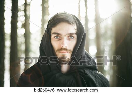 Stock Photograph - Caucasian man with beard wearing robe in forest. Fotosearch