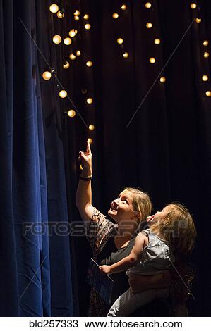 Caucasian mother and daughter looking up at blue curtain View Large Photo Image Stock Image - Caucasian mother and daughter looking up at blue curtain. Fotosearch