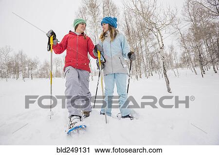 Stock Image - Caucasian mother and daughter snowshoeing. Fotosearch