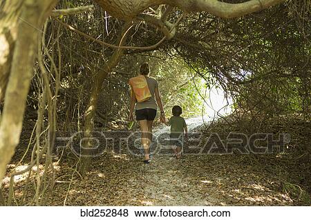 Stock Photo - Caucasian mother and son walking on path. Fotosearch