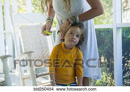 Picture - Caucasian mother applying sunscreen to face of son. Fotosearch