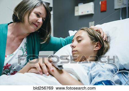 Caucasian mother comforting daughter in hospital View Large Photo Image Stock Photo - Caucasian mother comforting daughter in hospital. Fotosearch