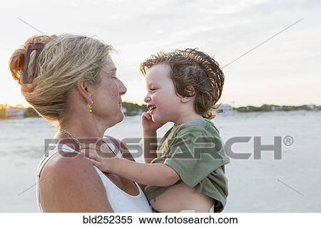 Stock Photography - Caucasian mother holding boy at beach. Fotosearch