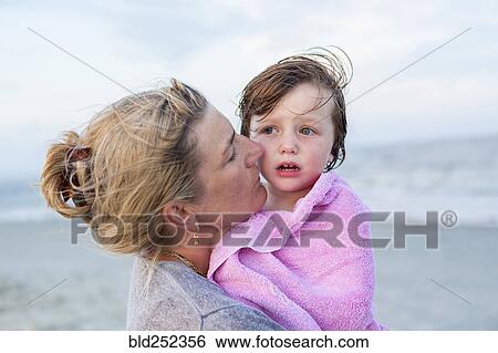 Stock Photograph - Caucasian mother holding son at beach. Fotosearch