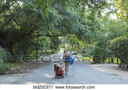 Caucasian mother pulling son and daughter in wagon View Large Photo Image Stock Photo - Caucasian mother pulling son and daughter in wagon. Fotosearch