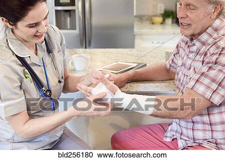 Caucasian nurse wrapping wrist of man View Large Photo Image Stock Image - Caucasian nurse wrapping wrist of man. Fotosearch