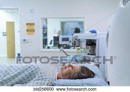 Stock Image - Caucasian patient laying at scanner. Fotosearch