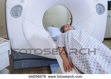 Stock Photo - Caucasian patient laying on scanner table. Fotosearch