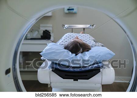 Stock Photography - Caucasian patient laying on scanner table. Fotosearch
