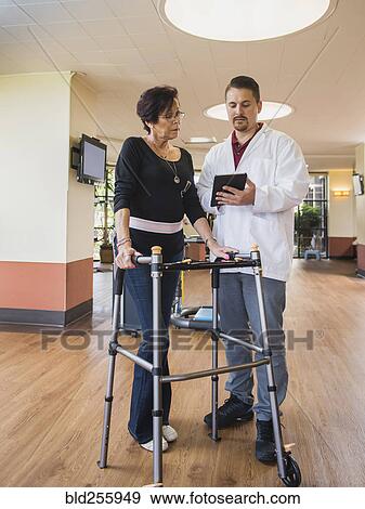 Caucasian physical therapist showing digital tablet to patient View Large Photo Image Stock Photo - Caucasian physical therapist showing digital tablet to patient. Fotosearch