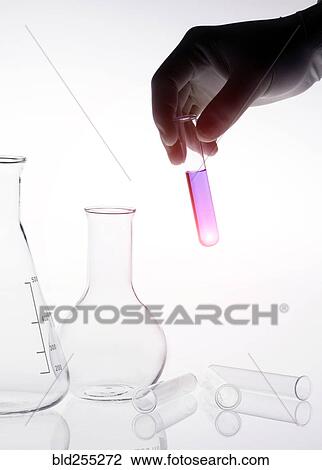 Stock Image - Caucasian scientist holding purple liquid in test tube. Fotosearch