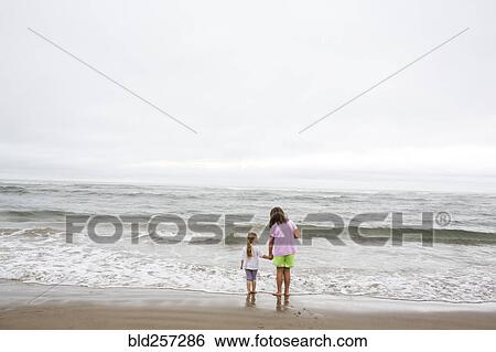 Caucasian sisters holding hands on beach View Large Photo Image Stock Photograph - Caucasian sisters holding hands on beach. Fotosearch