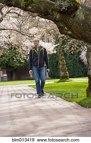 Caucasian student walking on campus View Large Photo Image Stock Photo - Caucasian student walking on campus. Fotosearch