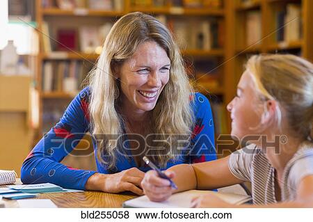 Caucasian teacher helping student in library View Large Photo Image Stock Photo - Caucasian teacher helping student in library. Fotosearch