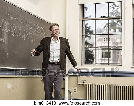 Stock Image - Caucasian teacher talking in classroom. Fotosearch