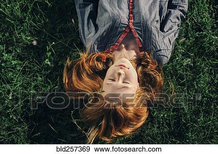 Stock Photo - Caucasian teenage girl laying in grass. Fotosearch