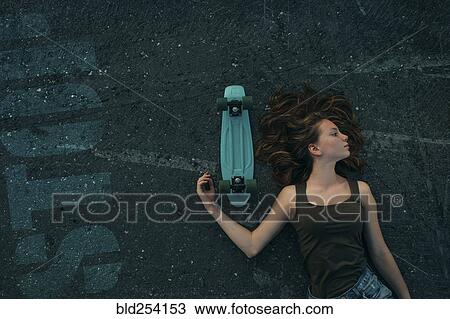 Caucasian teenage girl laying on pavement with skateboard View Large Photo Image Stock Image - Caucasian teenage girl laying on pavement with skateboard. Fotosearch