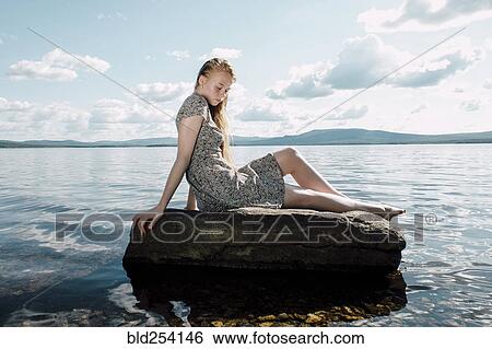 Caucasian teenage girl sitting on rock in ocean View Large Photo Image Stock Photograph - Caucasian teenage girl sitting on rock in ocean. Fotosearch