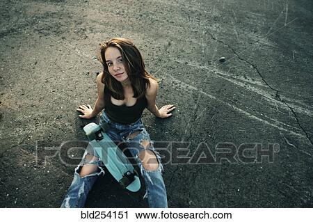 Caucasian teenage girl sitting on pavement with skateboard View Large Photo Image Stock Image - Caucasian teenage girl sitting on pavement with skateboard. Fotosearch