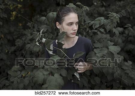 Stock Image - Caucasian teenage girl standing in leaves. Fotosearch