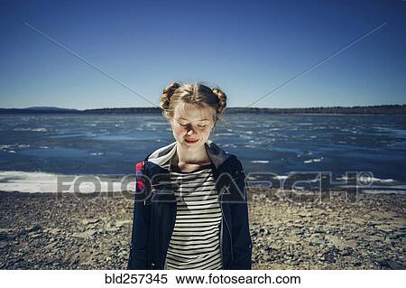 Stock Photography - Caucasian teenage girl standing on sunny beach. Fotosearch