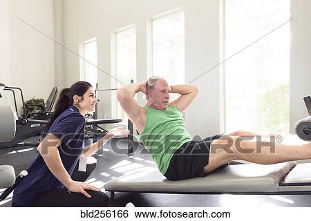 Caucasian trainer watching man doing sit-ups View Large Photo Image Stock Photograph - Caucasian trainer watching man doing sit-ups. Fotosearch