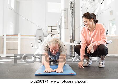 Caucasian trainer watching man stretching arms View Large Photo Image Stock Image - Caucasian trainer watching man stretching arms. Fotosearch