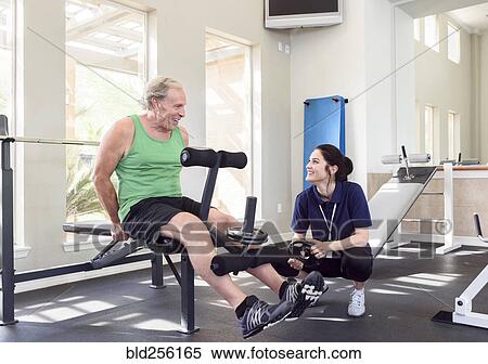 Caucasian trainer watching man strengthen legs View Large Photo Image Stock Photography - Caucasian trainer watching man strengthen legs. Fotosearch