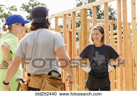 Caucasian volunteers standing at construction site View Large Photo Image Stock Image - Caucasian volunteers standing at construction site. Fotosearch