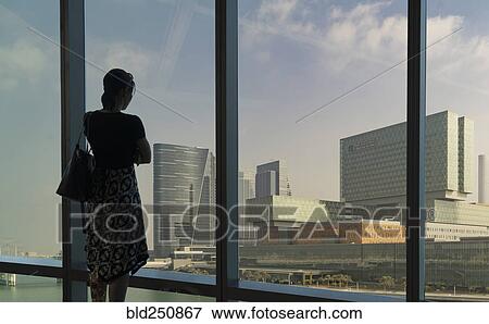 Caucasian woman admiring cityscape at window View Large Photo Image Stock Photo - Caucasian woman admiring cityscape at window. Fotosearch