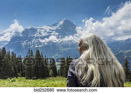 Stock Image - Caucasian woman admiring scenic view of mountain. Fotosearch