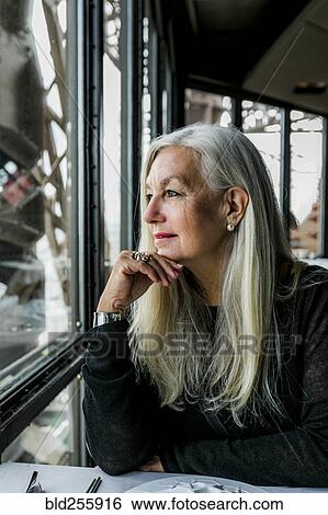 Caucasian woman admiring scenic view from restaurant window View Large Photo Image Stock Photograph - Caucasian woman admiring scenic view from restaurant window. Fotosearch