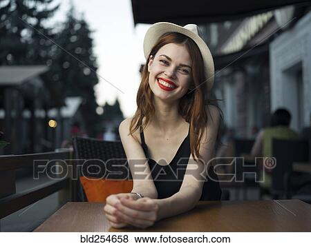 Stock Photo - Caucasian woman at sidewalk cafe smiling. Fotosearch