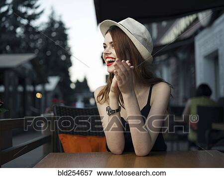 Stock Photo - Caucasian woman at sidewalk cafe laughing. Fotosearch