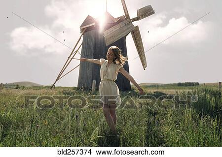 Caucasian woman balancing in grass near windmill View Large Photo Image Picture - Caucasian woman balancing in grass near windmill. Fotosearch