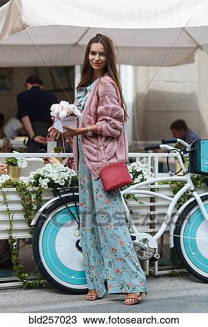 Caucasian woman carrying gift box near bicycle View Large Photo Image Stock Image - Caucasian woman carrying gift box near bicycle. Fotosearch