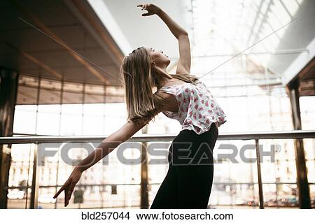 Picture - Caucasian woman dancing near railing. Fotosearch