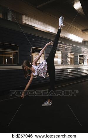 Stock Photograph - Caucasian woman dancing near train. Fotosearch