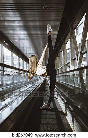 Stock Photo - Caucasian woman dancing on moving walkway. Fotosearch