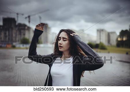 Stock Image - Caucasian woman dancing outdoors. Fotosearch