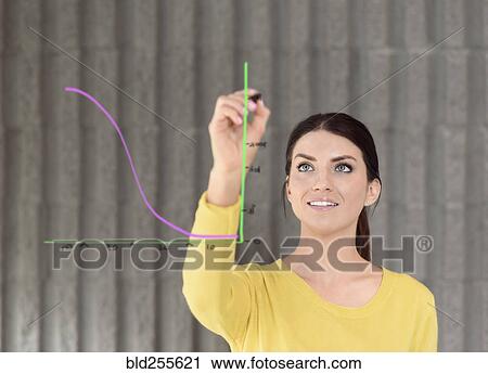 Stock Image - Caucasian woman drawing chart on glass wall. Fotosearch