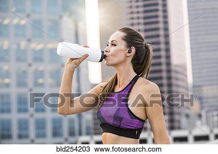 Caucasian woman drinking water in city View Large Photo Image Stock Image - Caucasian woman drinking water in city. Fotosearch