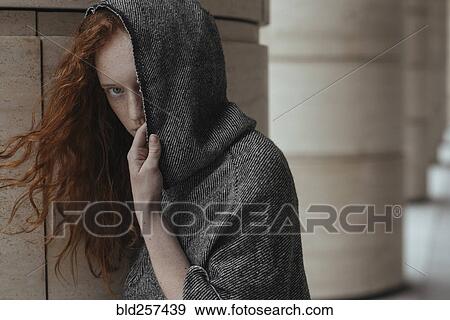 Stock Photo - Caucasian woman hiding face behind hood. Fotosearch