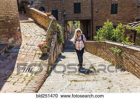 Stock Image - Caucasian woman hiking urban hill. Fotosearch