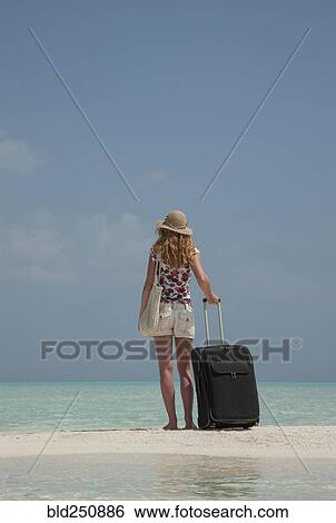Caucasian woman holding suitcase on ocean beach View Large Photo Image Stock Photograph - Caucasian woman holding suitcase on ocean beach. Fotosearch
