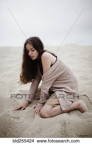 Caucasian woman kneeling in sand View Large Photo Image Picture - Caucasian woman kneeling in sand. Fotosearch