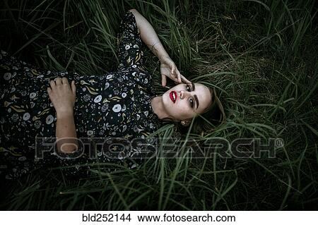 Picture - Caucasian woman laying in grass. Fotosearch